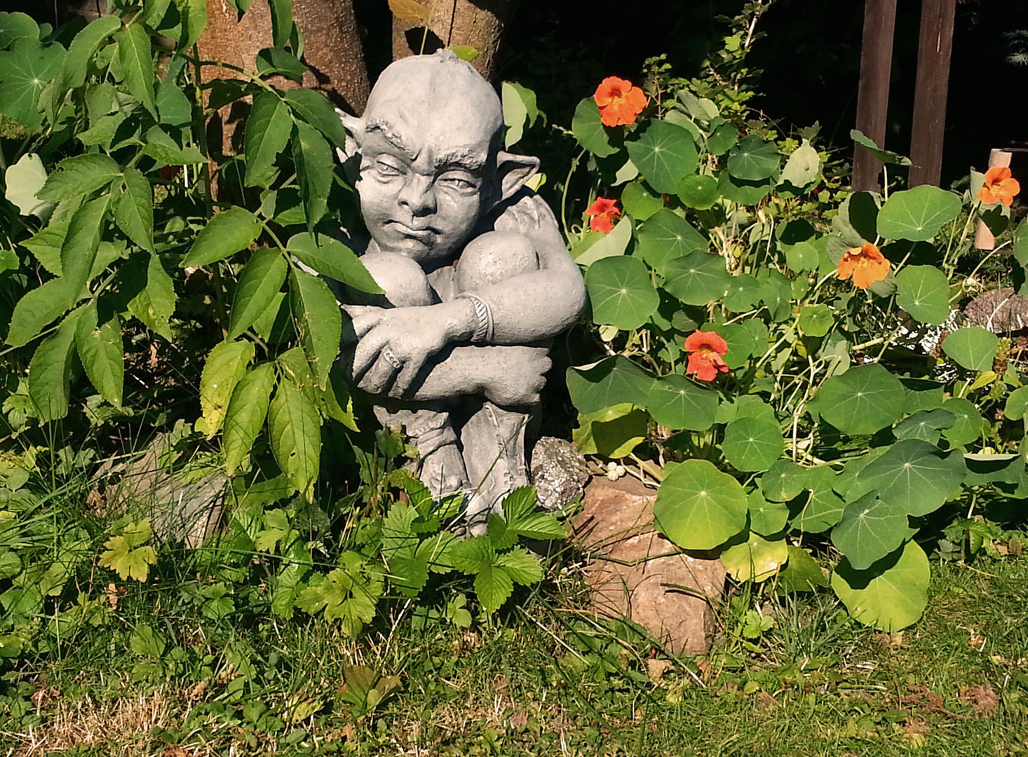 Gartenfigur zwischen Gartenpflanzen